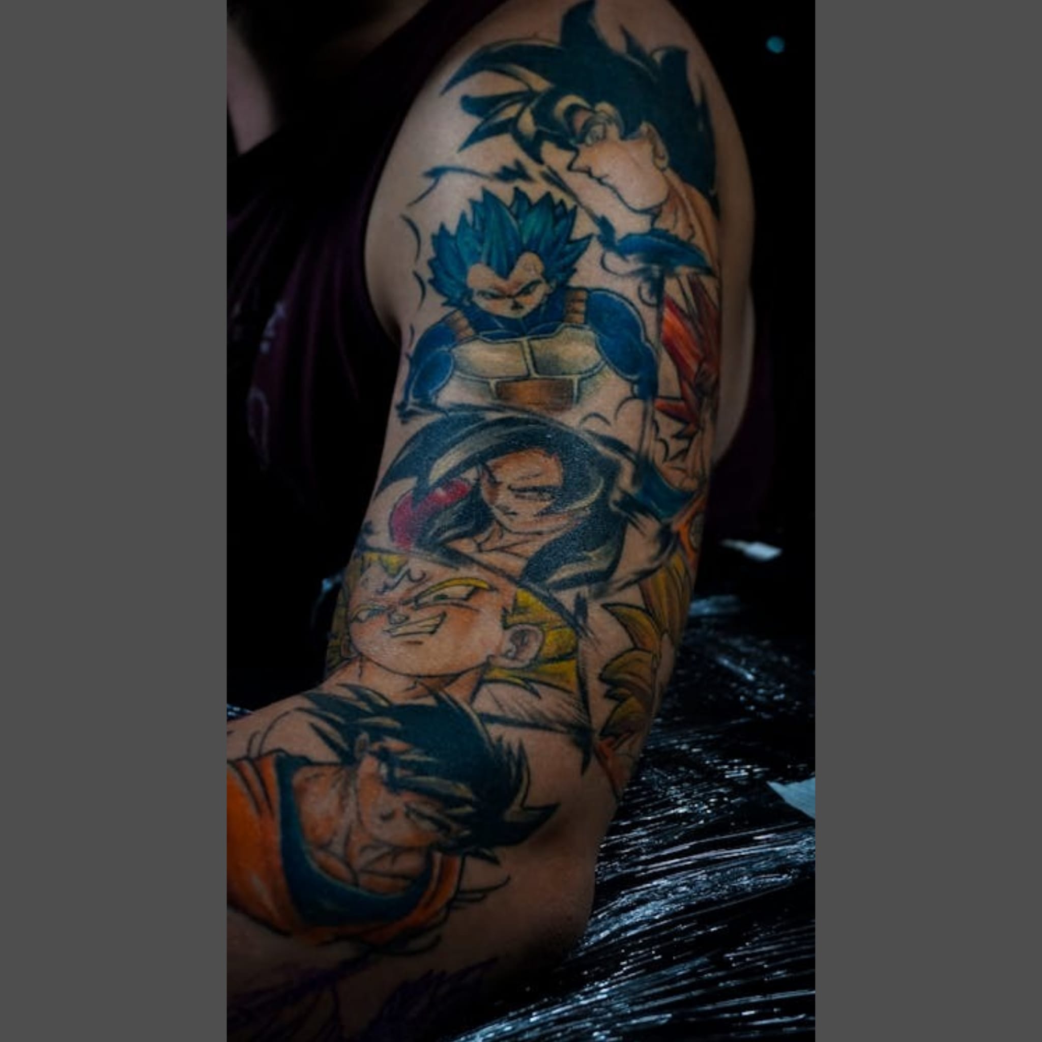 Colourful anime tattoos on top of arm
