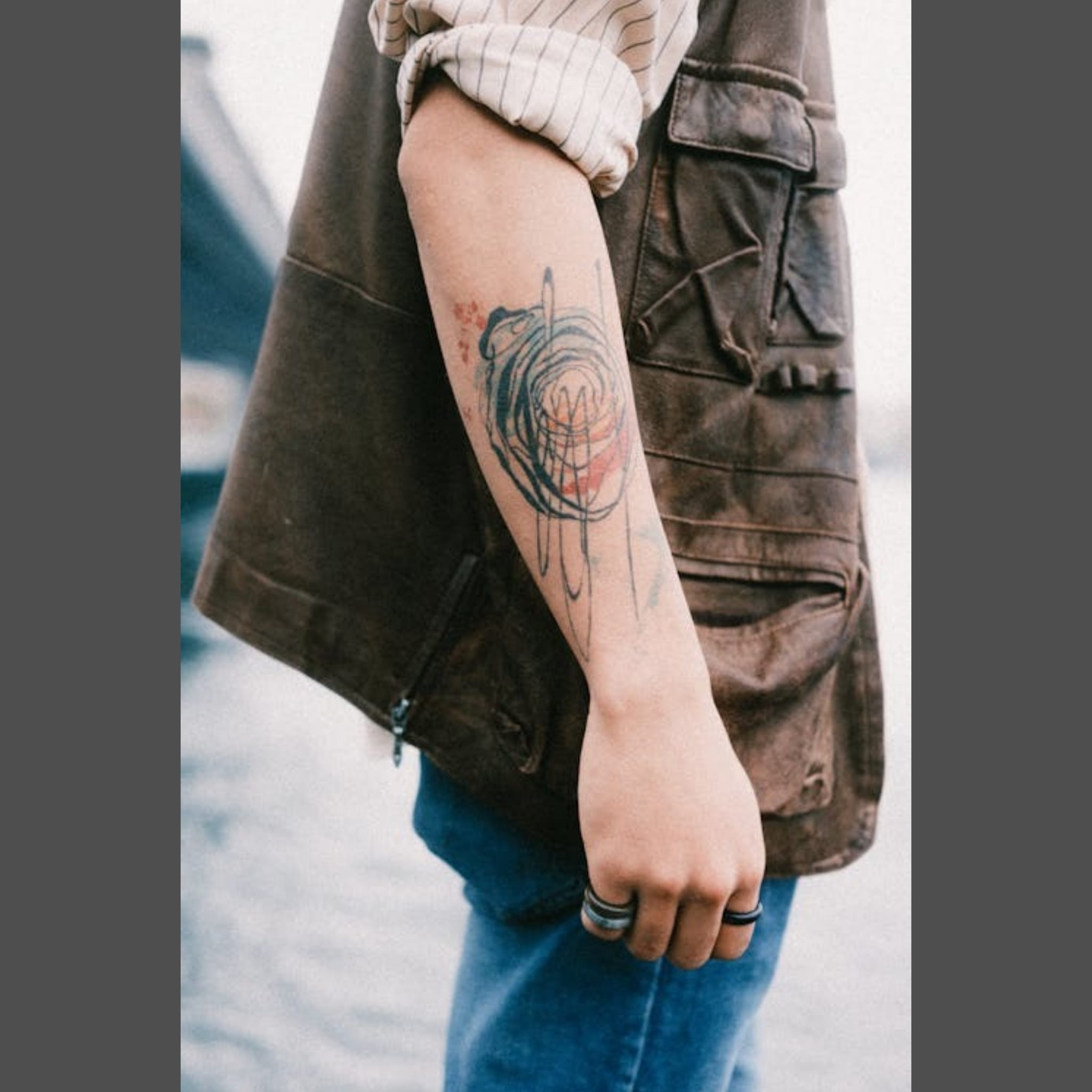 Man with rolled up sleeve showing his colourful tattoo on his right arm