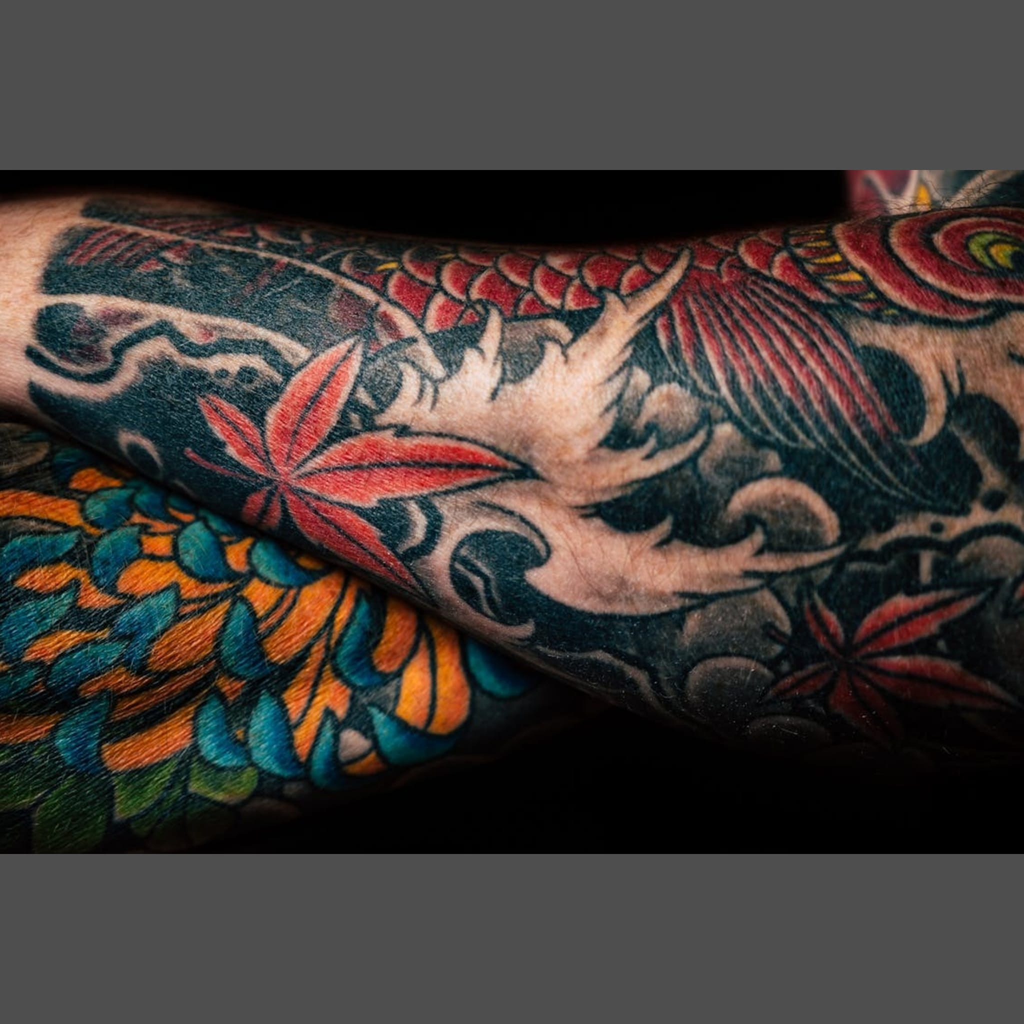 Close-up of man with crossed arms showing his colourful traditional japanese sleeves